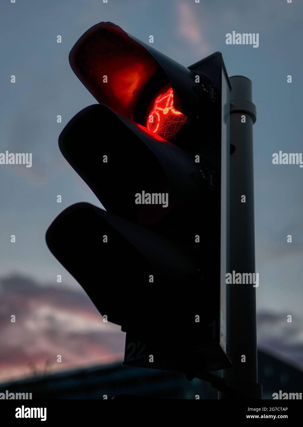 Closeup evening photo of a traffic light showing red light for
