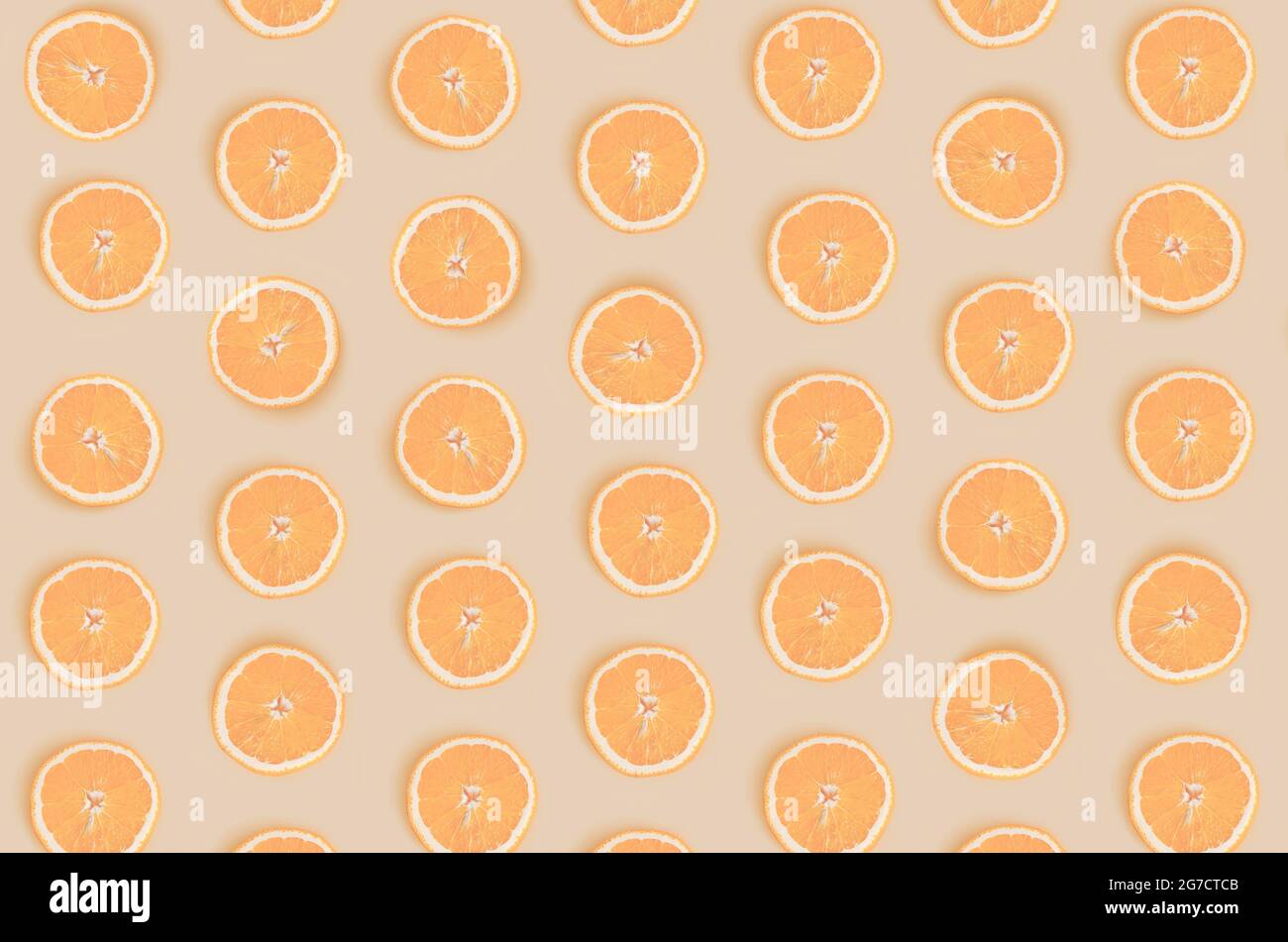 Fruit pattern from round orange slices isolated on light orange background. View from above. Stock Photo