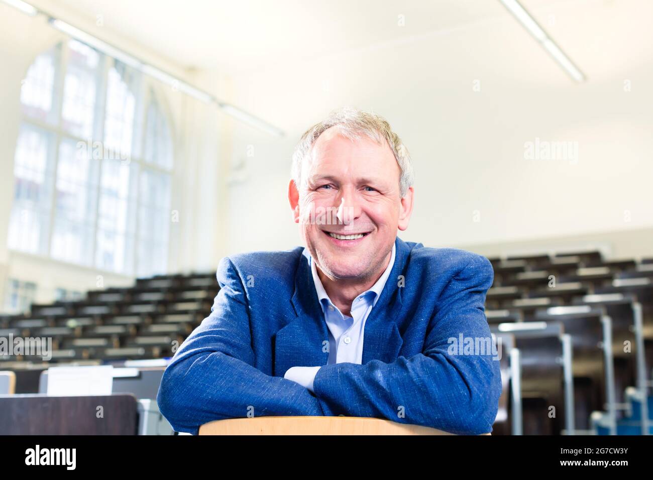 College professor giving lecture and standing at desk Stock Photo - Alamy