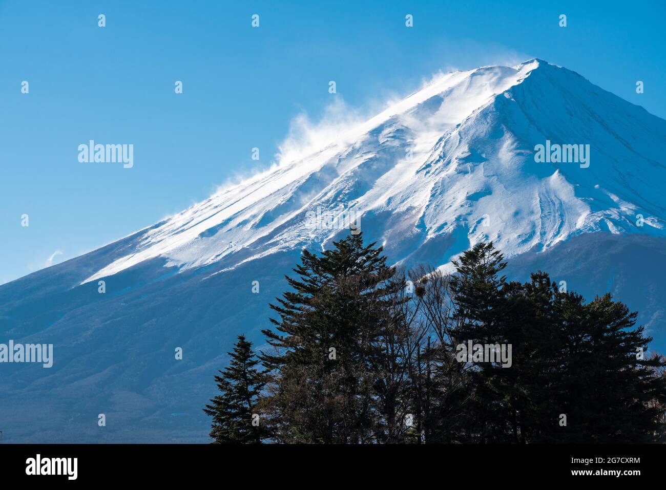 Snow covered icy peak of Mount Fuji. Japan's highest mountain and active volcano. Winds blowing snow from the mountain peak. Stock Photo