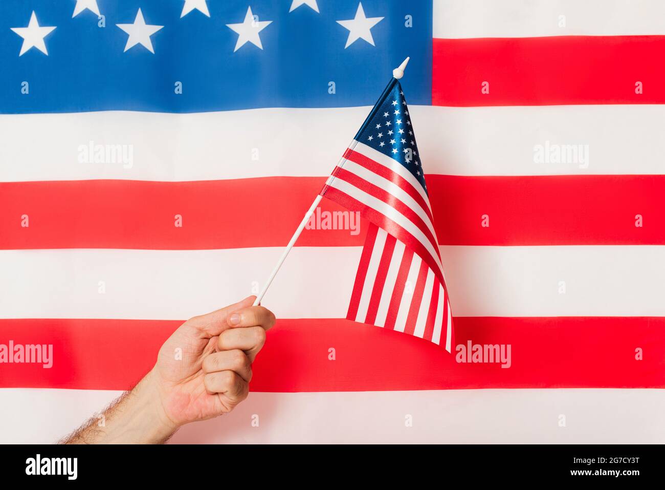 cropped view of patriotic man holding flag of america against american ...