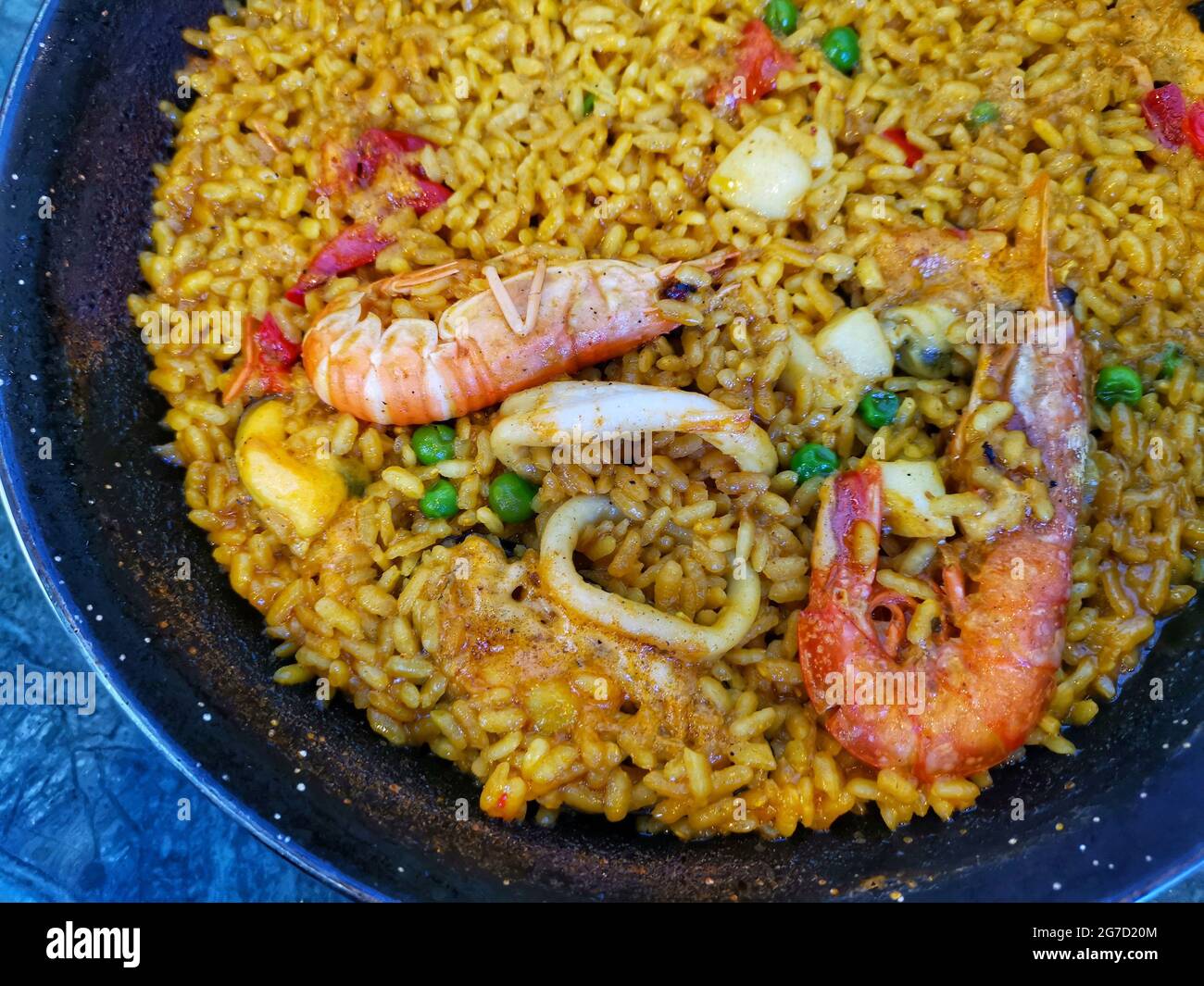 Top view of delicious Spanish seafood paella with shrimp and peas in a