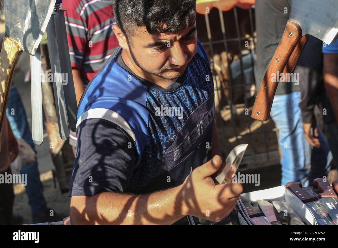 A Palestinian man holds a knife at a livestock market in preparation for the upcoming Muslim Eid al-Adha holiday in Dair Al-Balah city south Gaza Strip. (Photo by Ahmed Zakot / SOPA Images/Sipa USA) Stock Photo