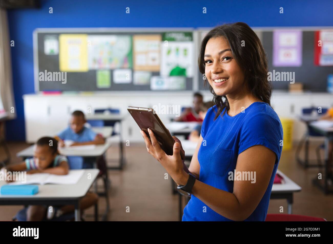 Portrait of african american female teacher holding digital tablet in ...