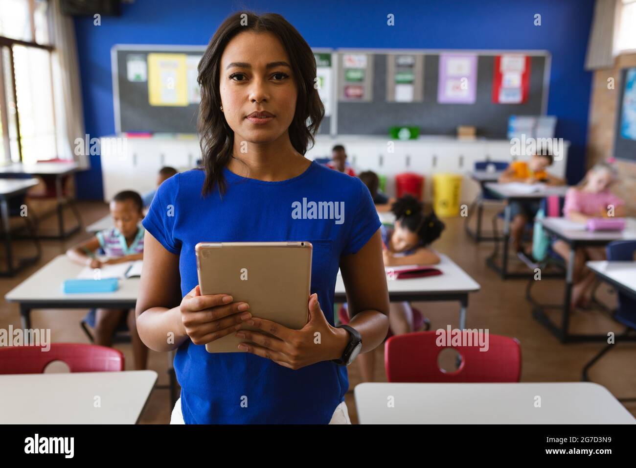 Portrait of african american female teacher holding digital tablet in ...