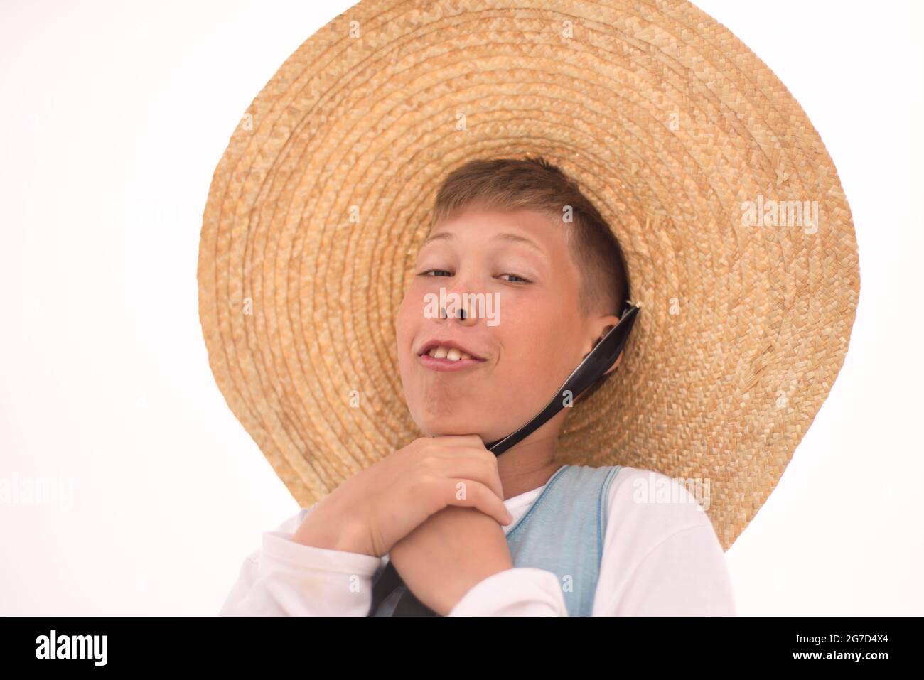 The face of a boy in a big straw hat. Smile. Humor. Trends. High quality photo Stock Photo