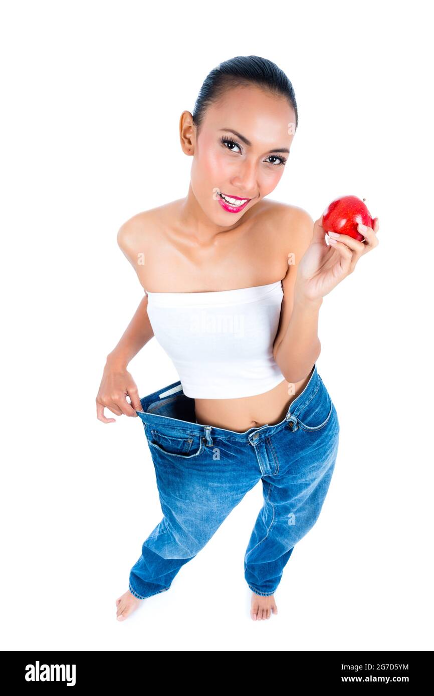 Young Asian woman losing weight by living healthy and eating fruit Stock Photo