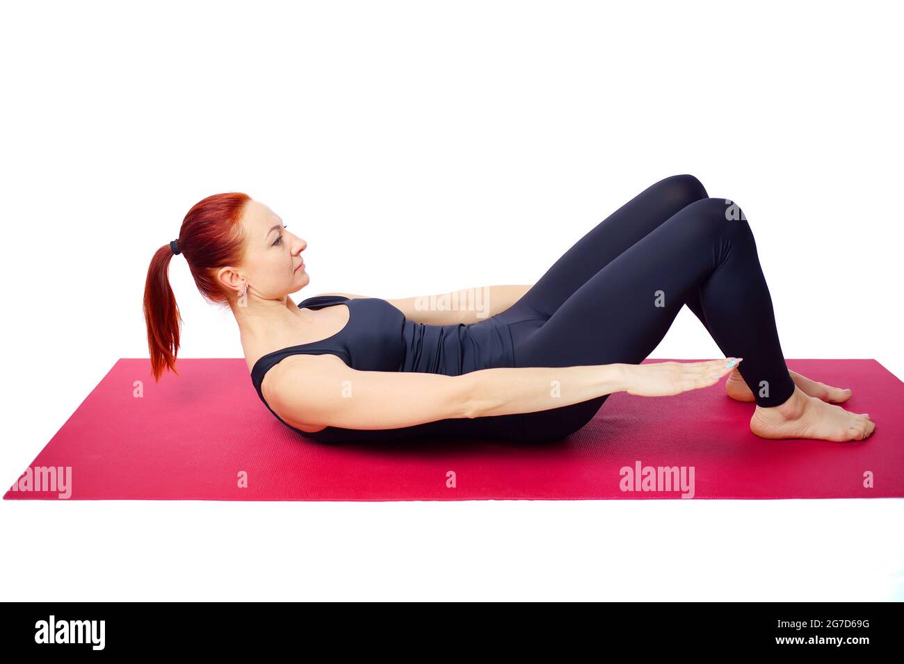 A beautiful slender woman performs an exercise to develop the strength of the abdominal muscles on a gym mat. Diaphragm breathing. Isolated on a white background. Stock Photo