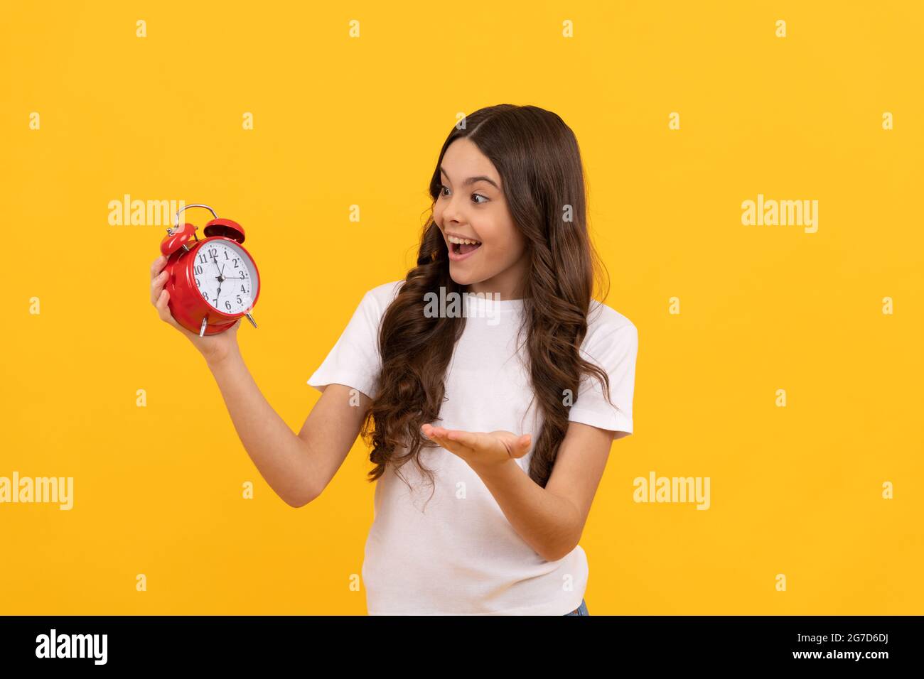 happy child hold retro alarm clock showing time, morning Stock Photo