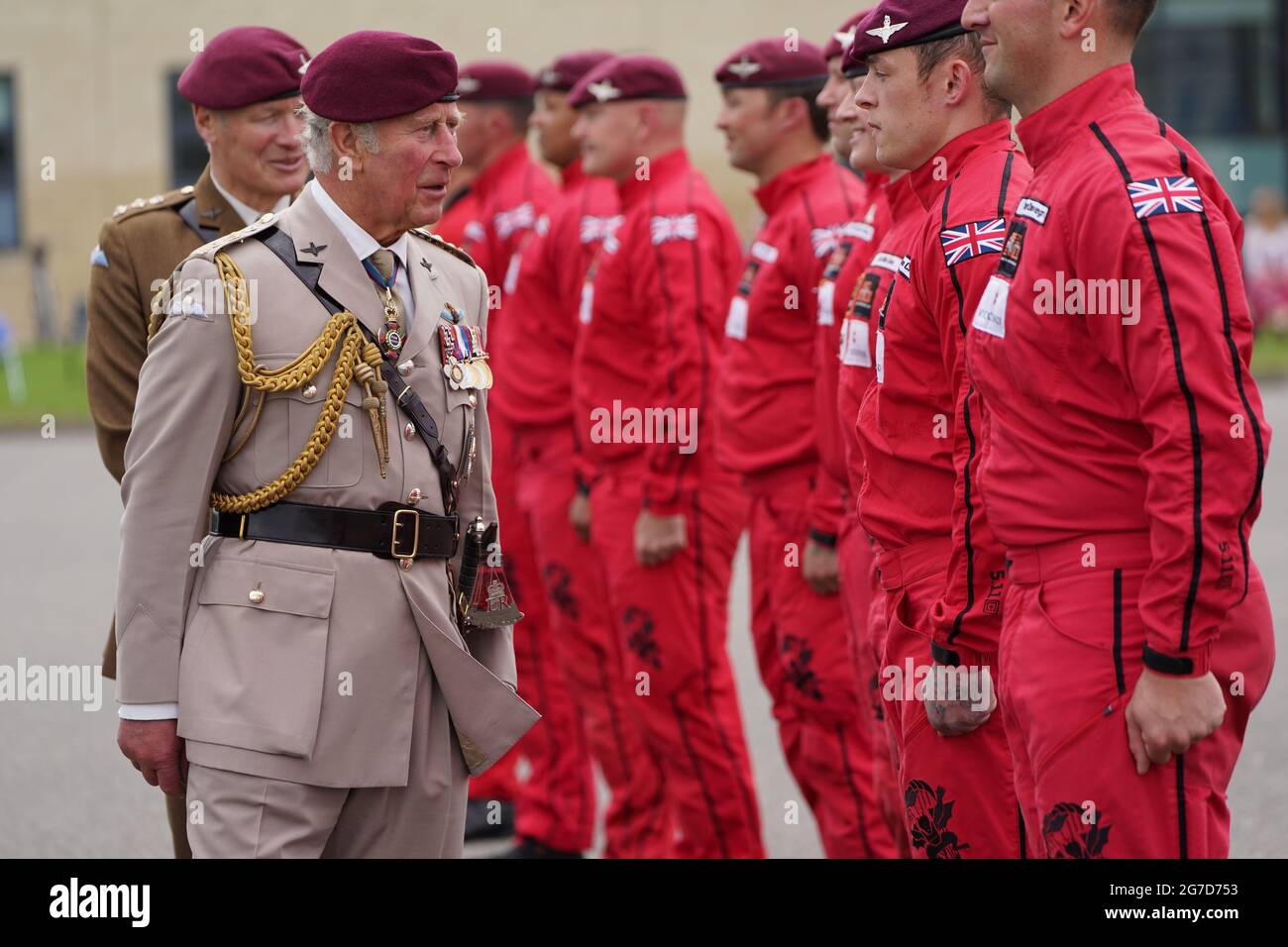 The Prince of Wales speaks to members of the Red Devils, the Parachute Regiment's parachute display team, during a ceremony to new to the Parachute Regiment at Merville Barracks in