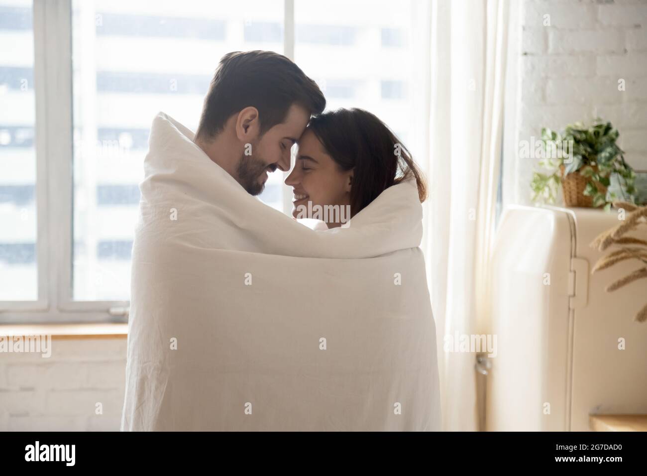 Couple awakened together wrapped in blanket standing together in kitchen Stock Photo Alamy