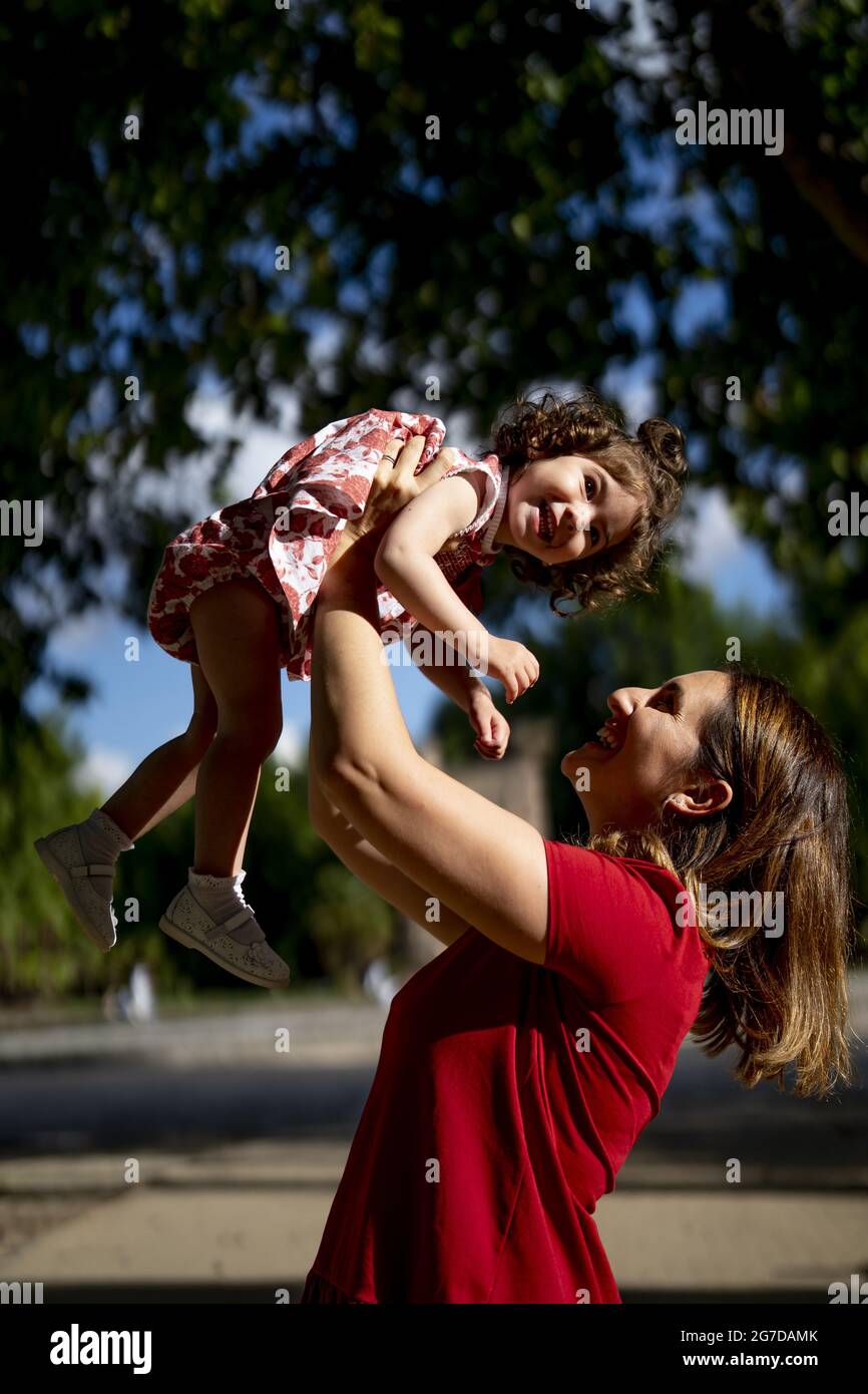 Mother throwing his daughter up while having a nice family time in a