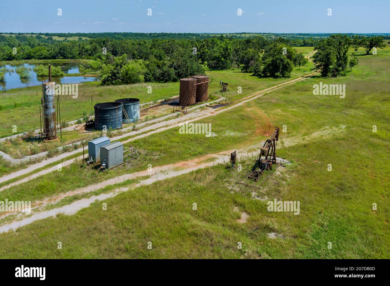 Pump jack on the of oil-gas pump jack out in field behind Oklahoma prairie Stock Photo