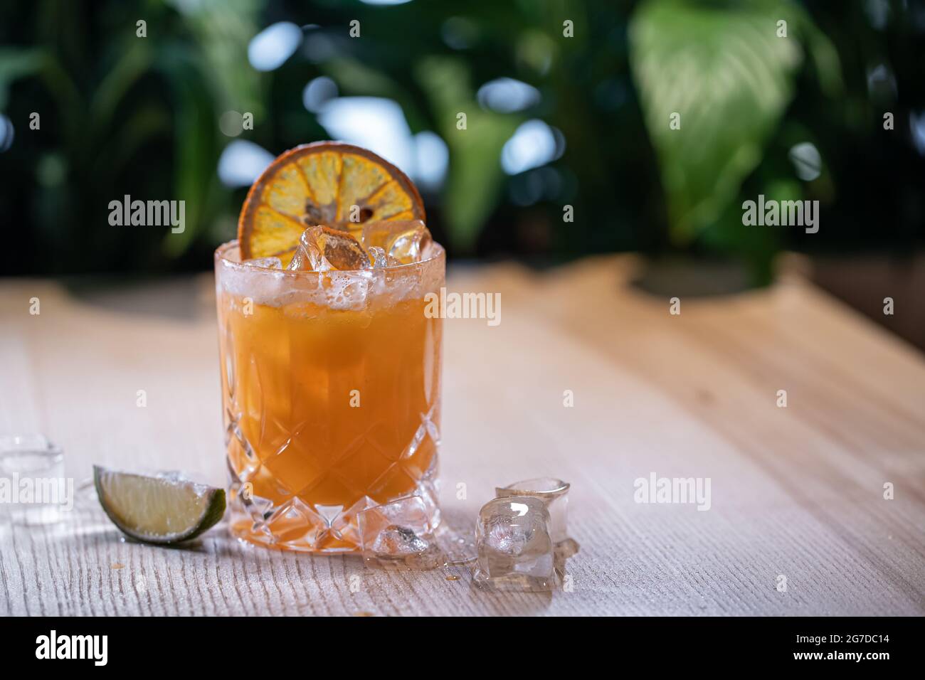 lemonade in glass or refreshing drink with orange juice, lime and ice on table Stock Photo