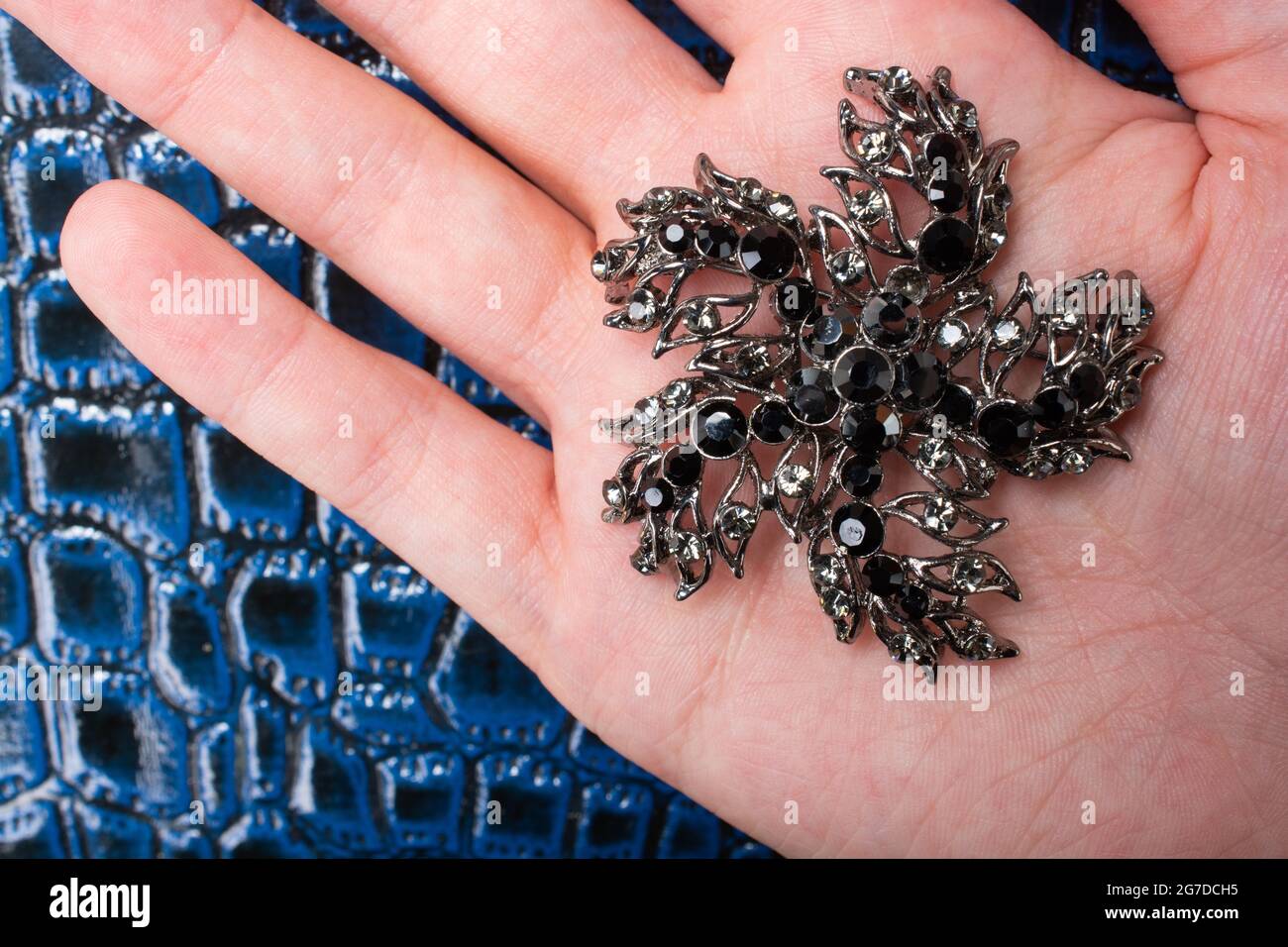 Hand holding a jewelry decoration with black precious stones Stock