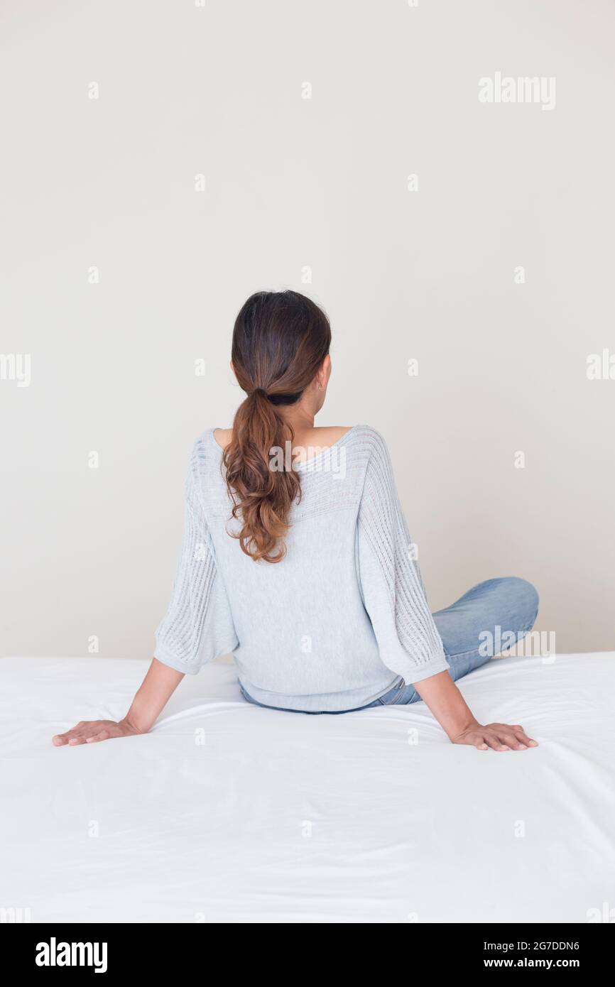Rear view of a woman staring at a wall Stock Photo