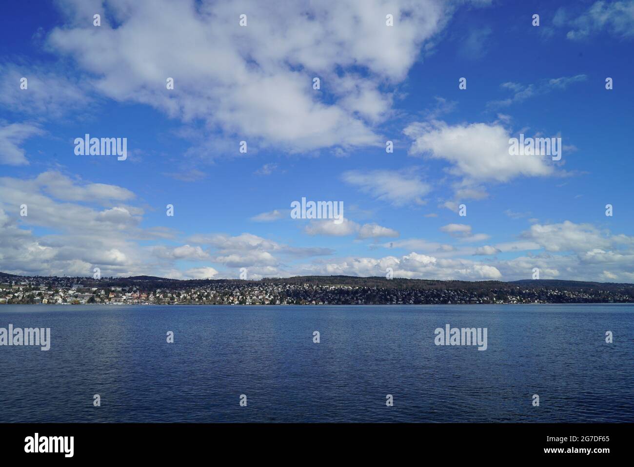 Landscape of a lake surrounded by a town under a blue cloudy sky Stock ...