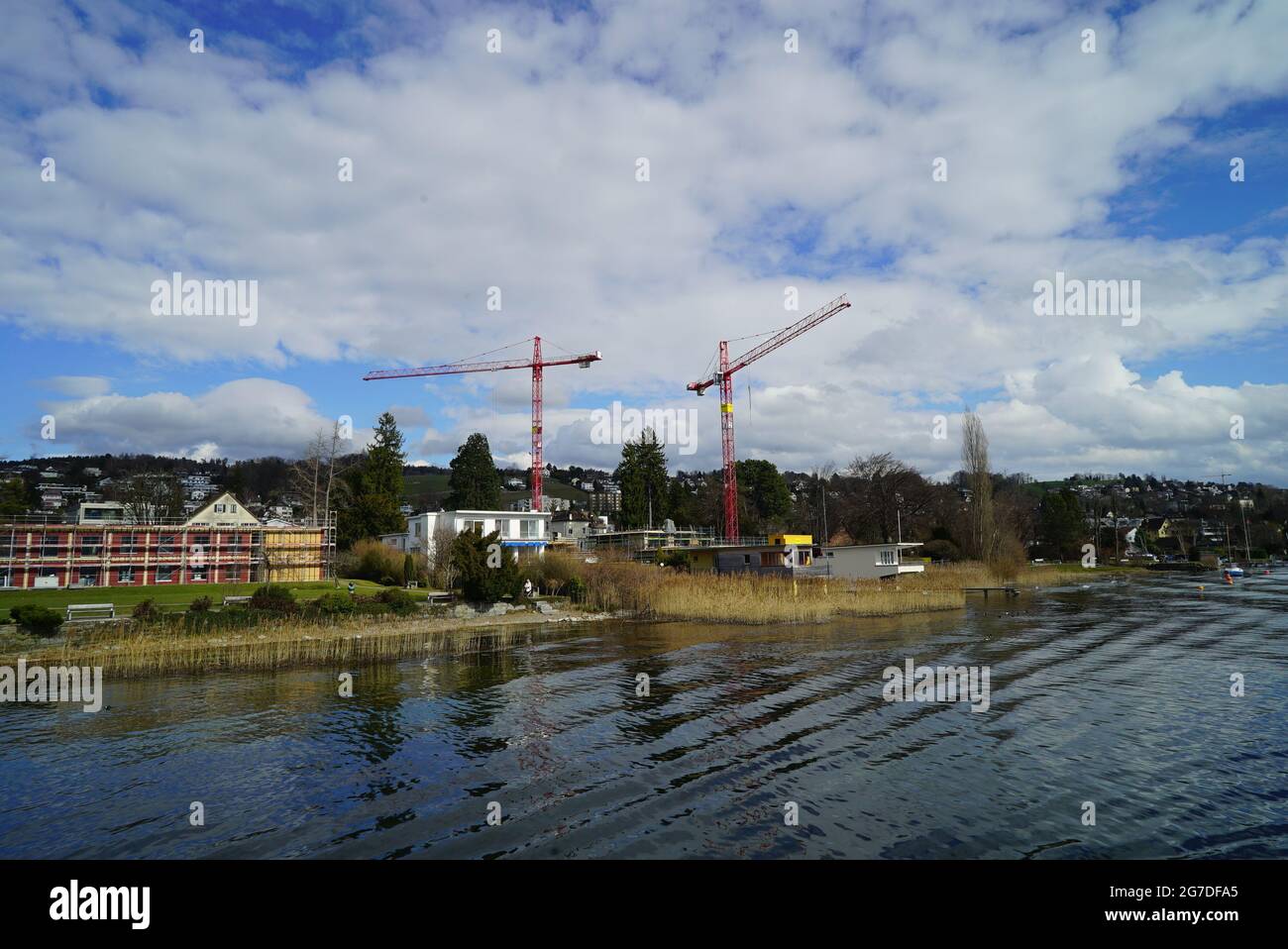 Lake surrounded by houses and greenery under a blue cloudy sky Stock ...
