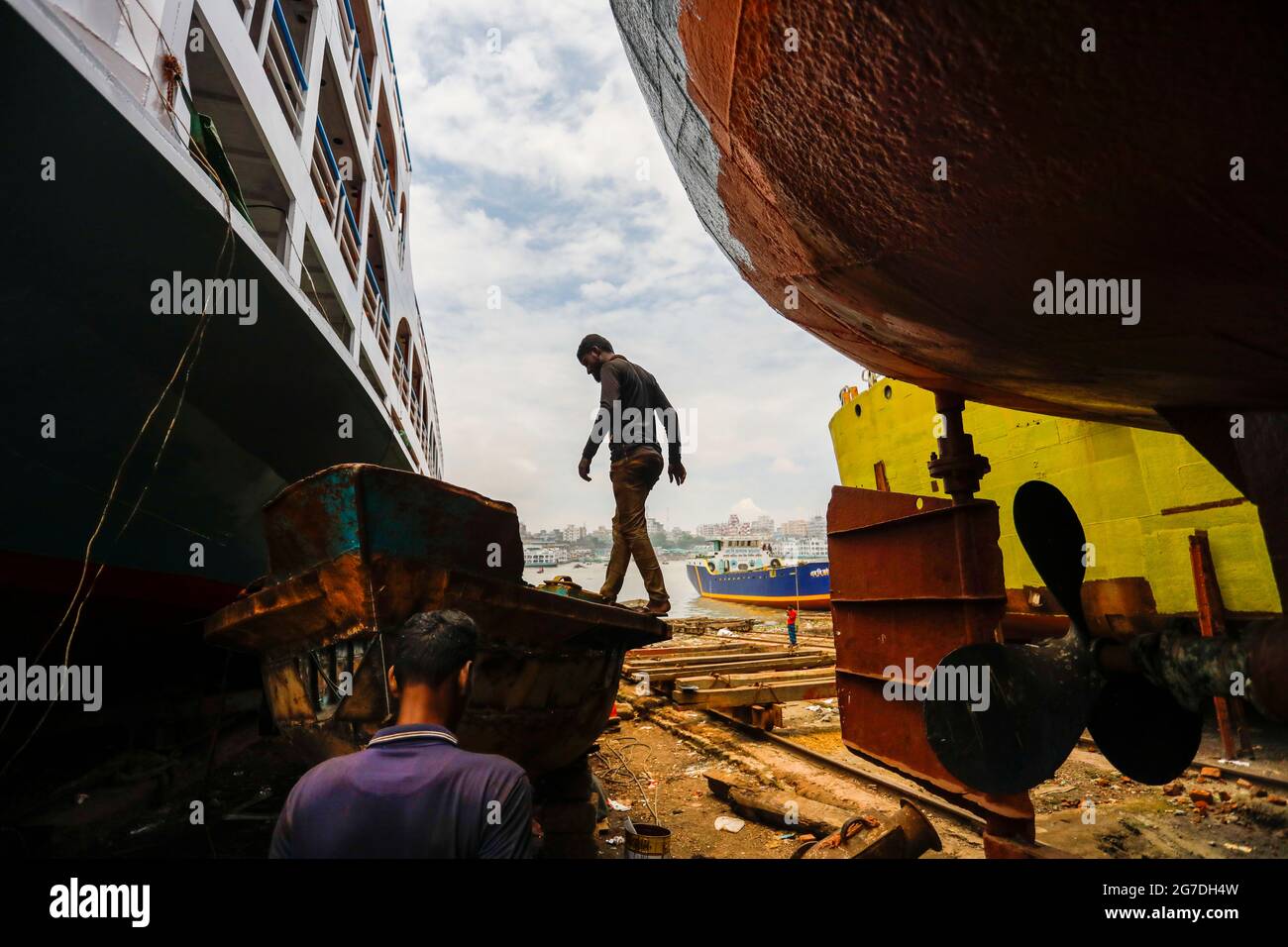 Bangladeshi workers repair a vessel at a dockyard on the bank of River Buriganga, in Keraniganj, near Dhaka, Bangladesh, July 13, 2021. With an increa Stock Photo