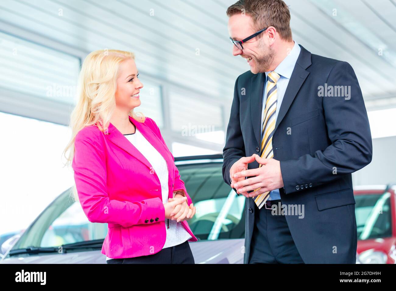 Woman buying car at dealership and consulting salesman Stock Photo