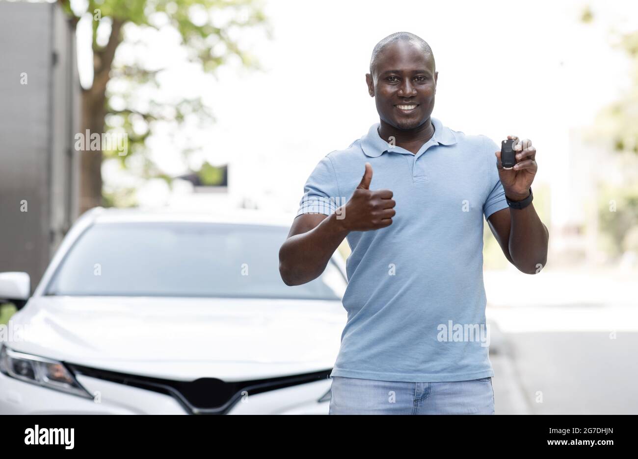 Happy black man showing car key and thumb up Stock Photo - Alamy