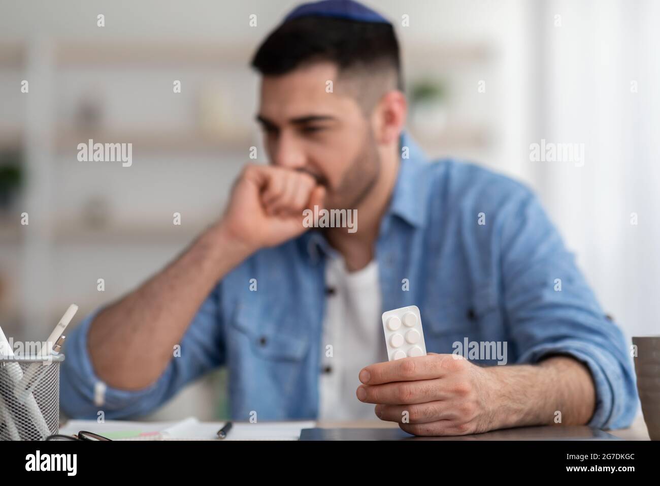Young man suffering from cold, coughing holding tablets Stock Photo Alamy