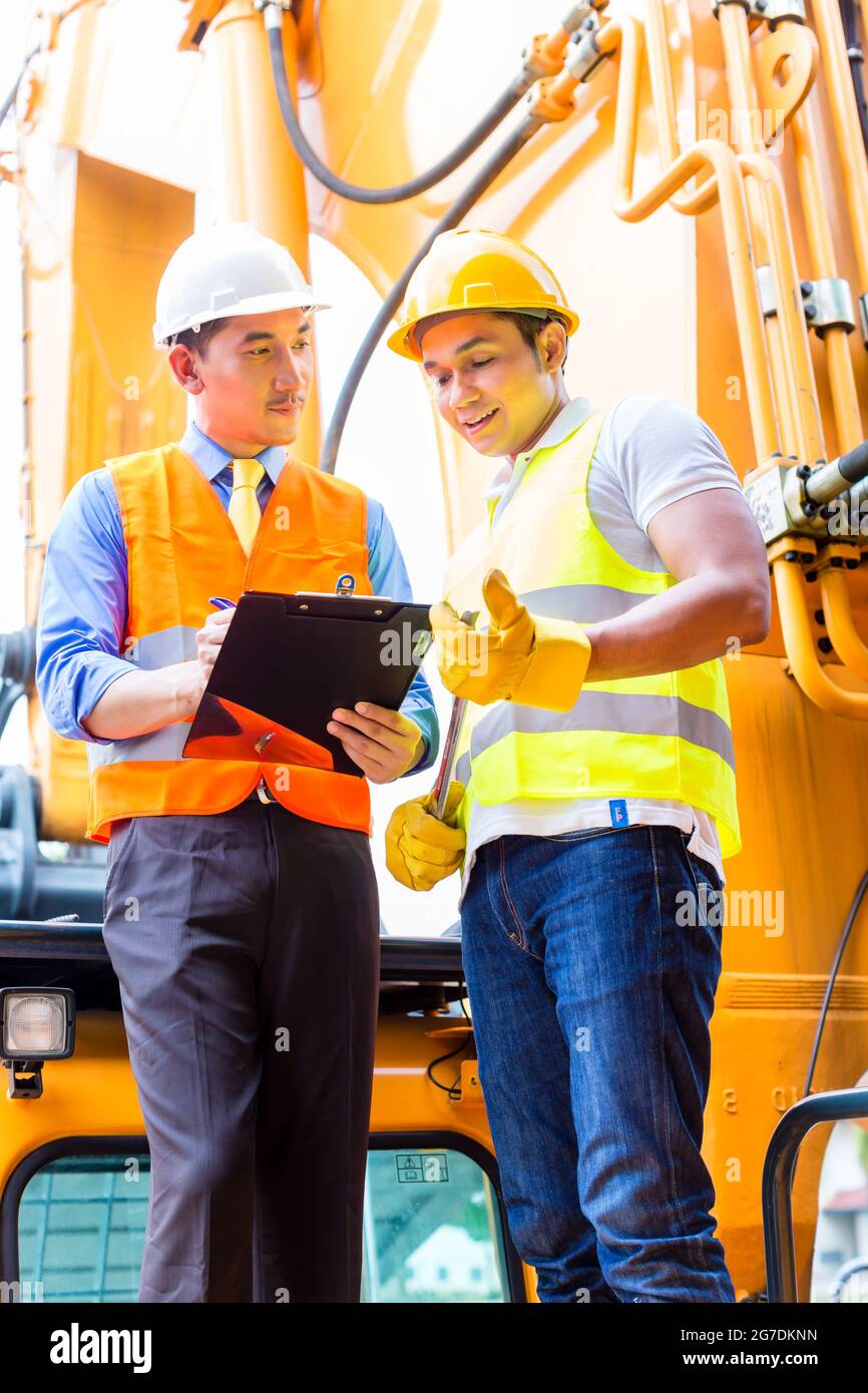 Asian motor mechanic discussing with foreman task list in vehicle workshop Stock Photo