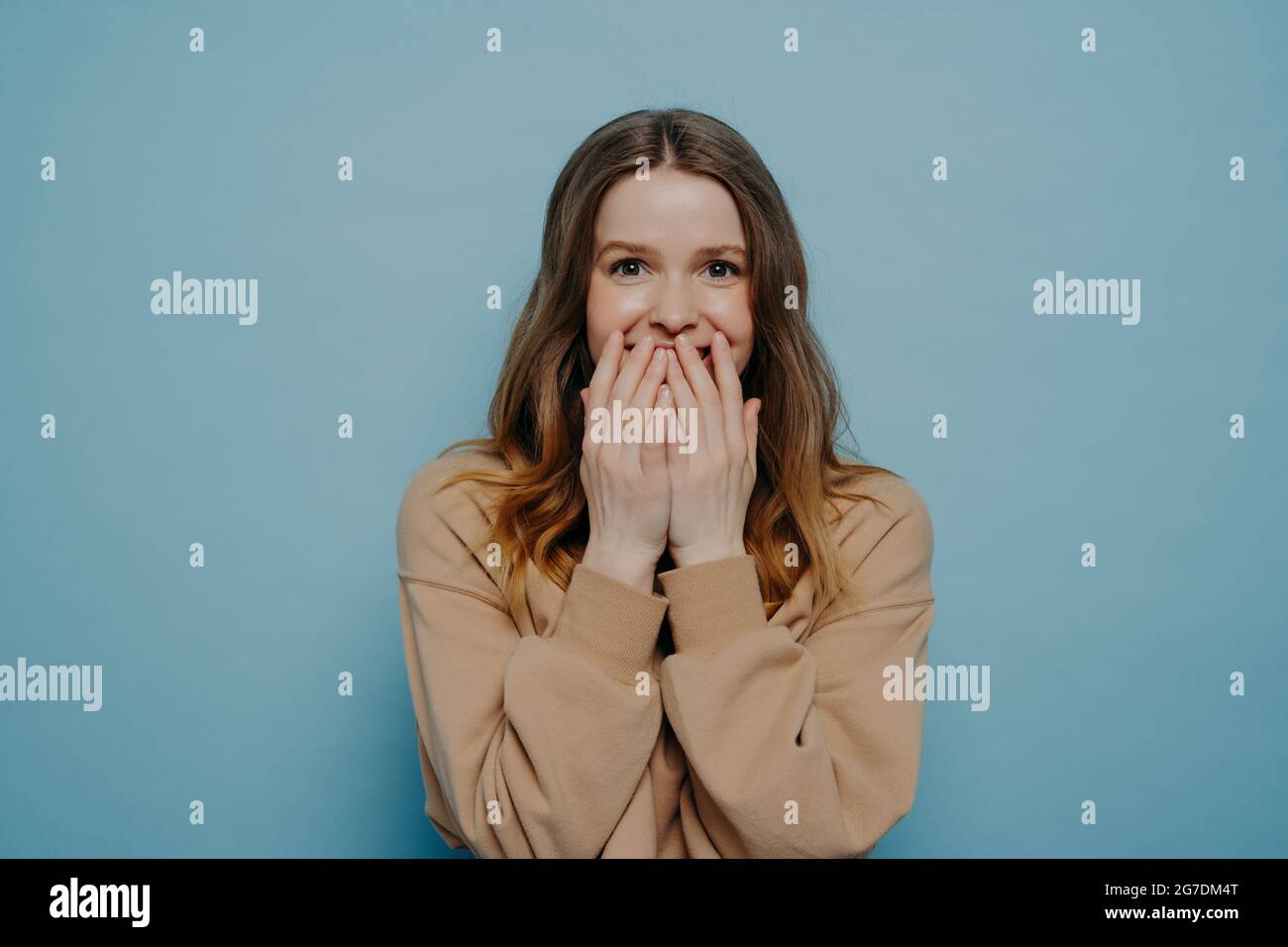 Surprised teenage girl covering mouth with hands Stock Photo