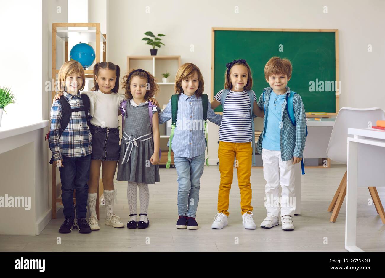 Group portrait of happy elementary school children standing in a modern classroom Stock Photo