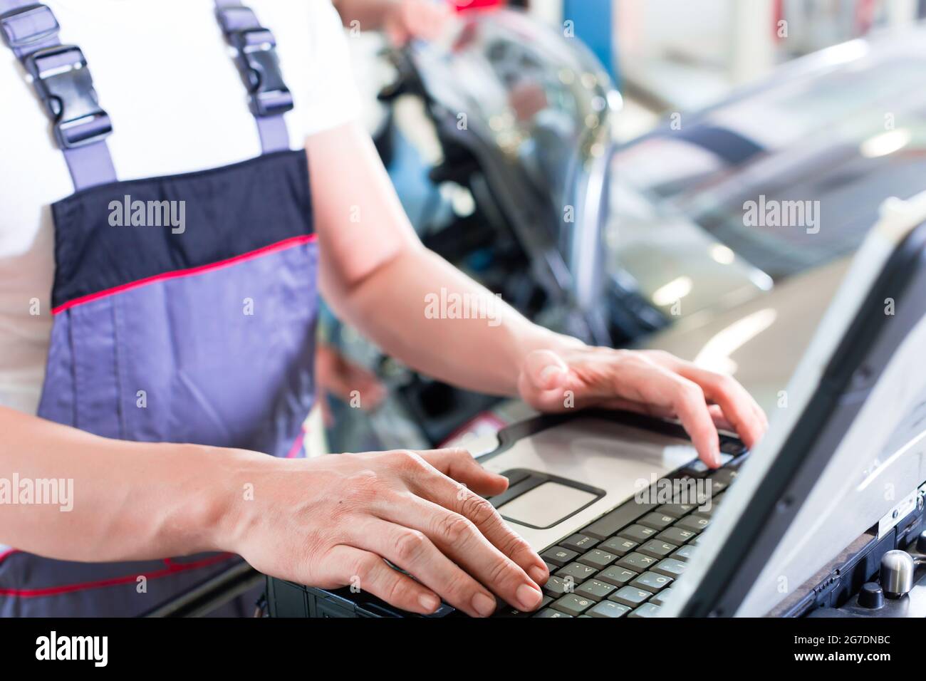 car mechanic checking auto engine with diagnostics tool in his workshop Stock Photo