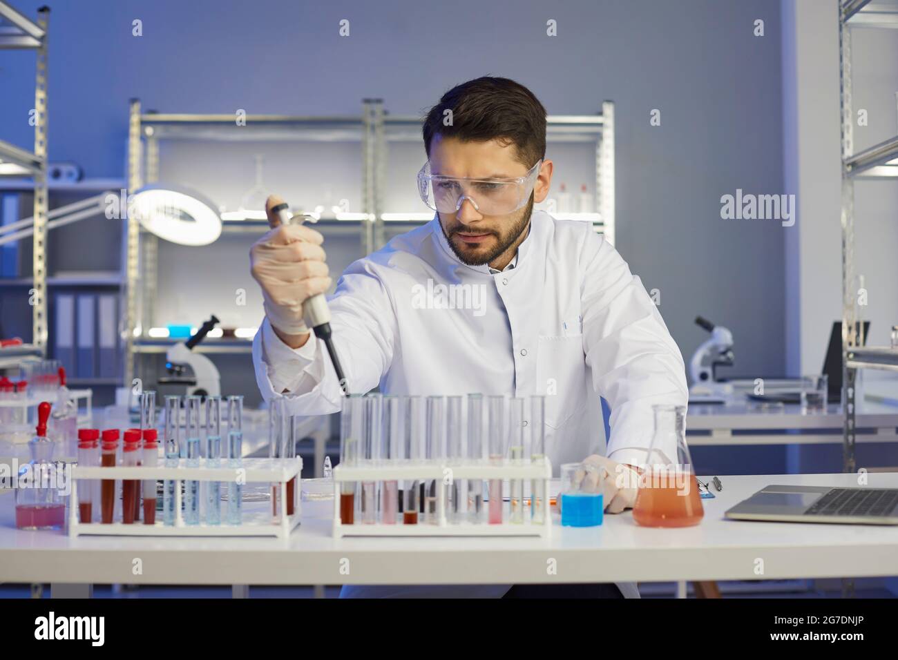 Young scientist working with samples in a pharma or biotech scientific laboratory Stock Photo