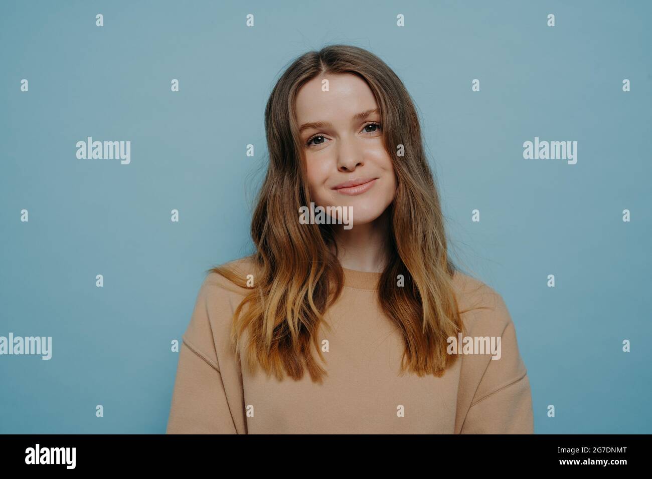 Positive young girl smiling at camera posing over blue background Stock ...