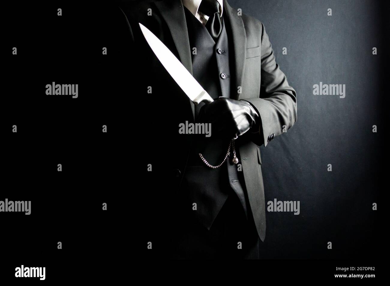 Portrait of Man in Dark Suit and Leather Gloves Holding Sharp Knife on Black Background. Stylish Gentleman Who Will Cut You. Mafia Hitman. Stock Photo