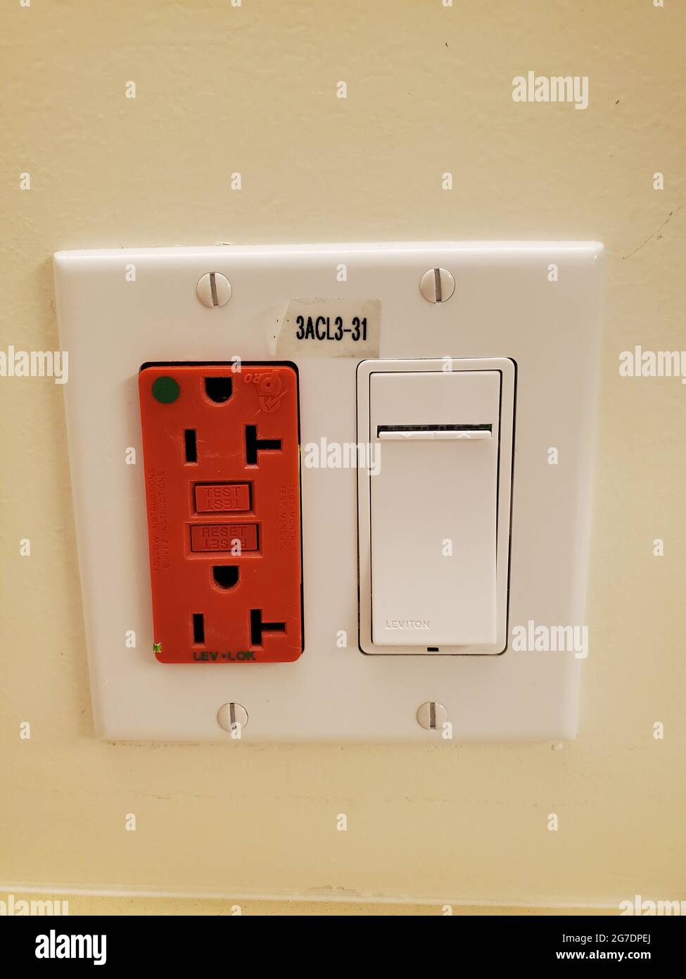 Close-up of a wall plate, with a switch and red-colored emergency backup power outlets in a medical setting in San Francisco, California, April 18, 2021. () Stock Photo
