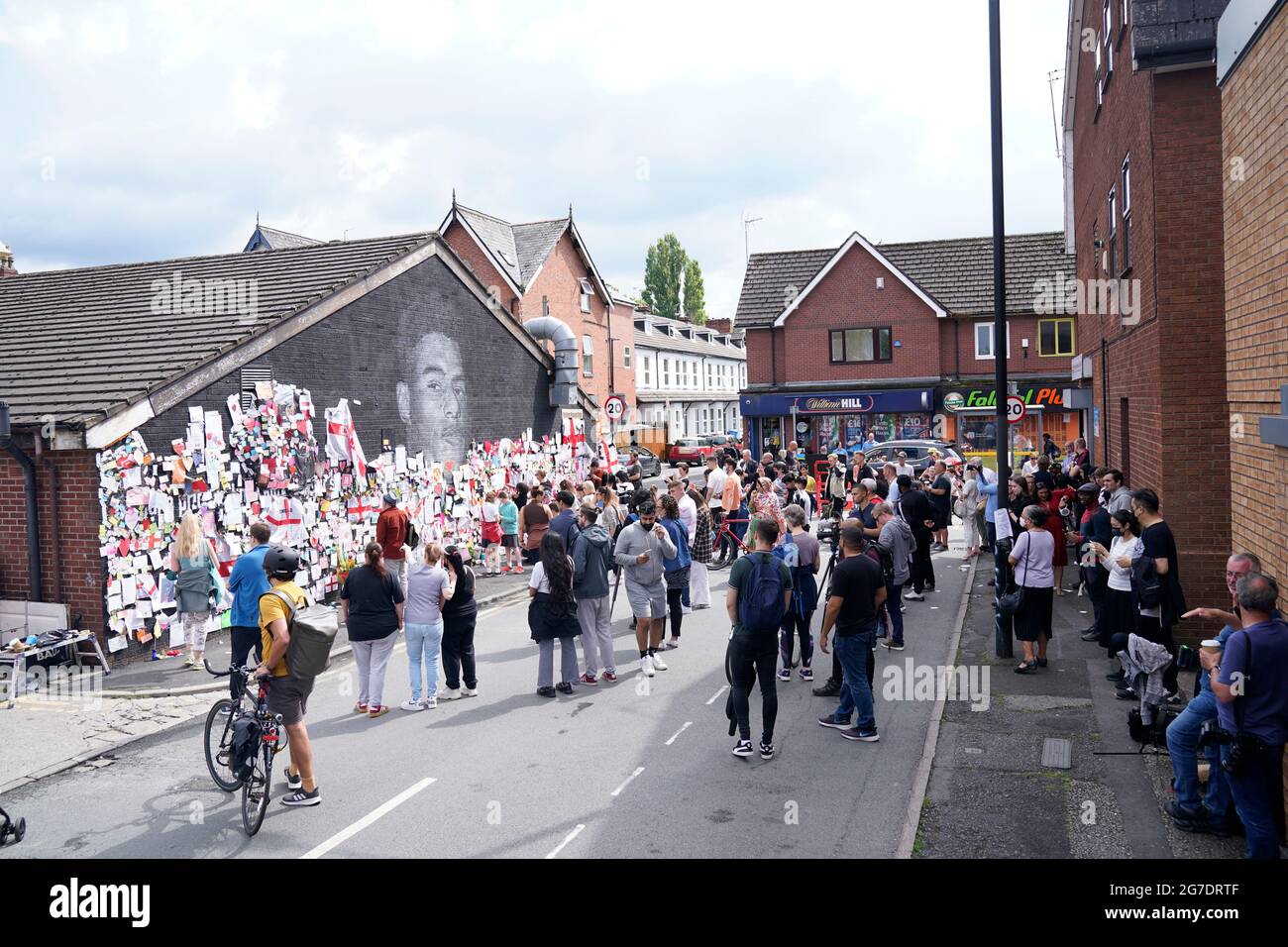 People gather to view the messages of support at the mural of