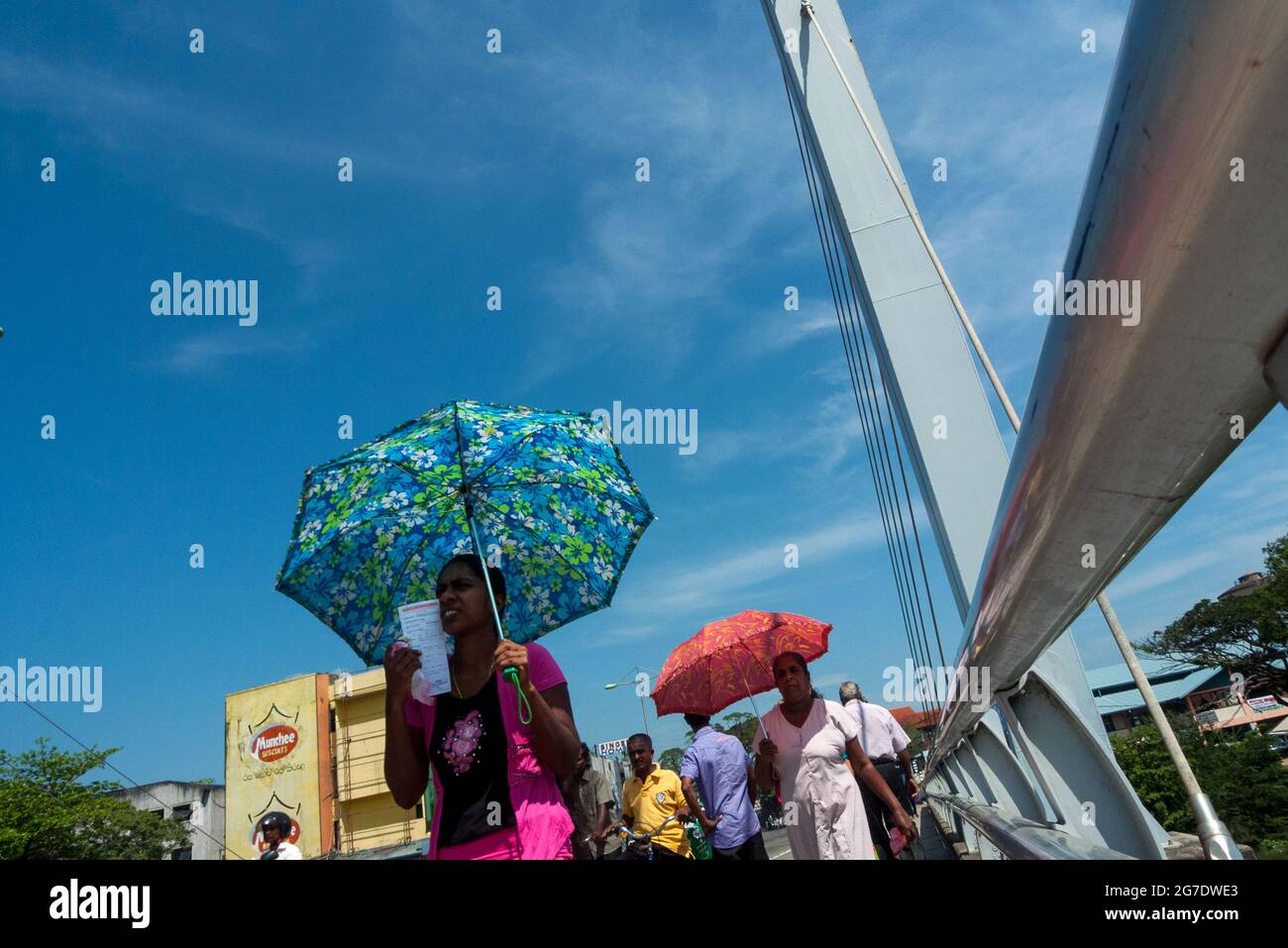 Matara, Sri Lanka, Asia: two women shelter from the sun with umbrellas while walking Stock Photo