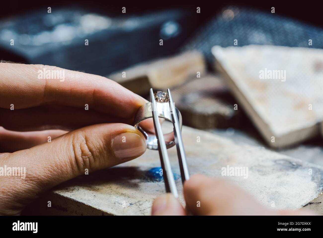 Closeup of Jeweler setting a precious stone with pincers on a ring