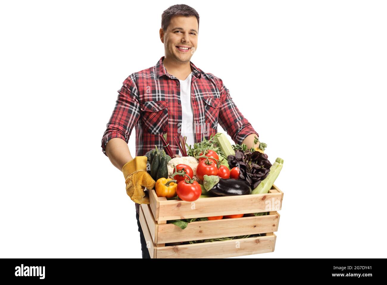 Farmer holding a crate with vegetables and looking at camera isolated ...