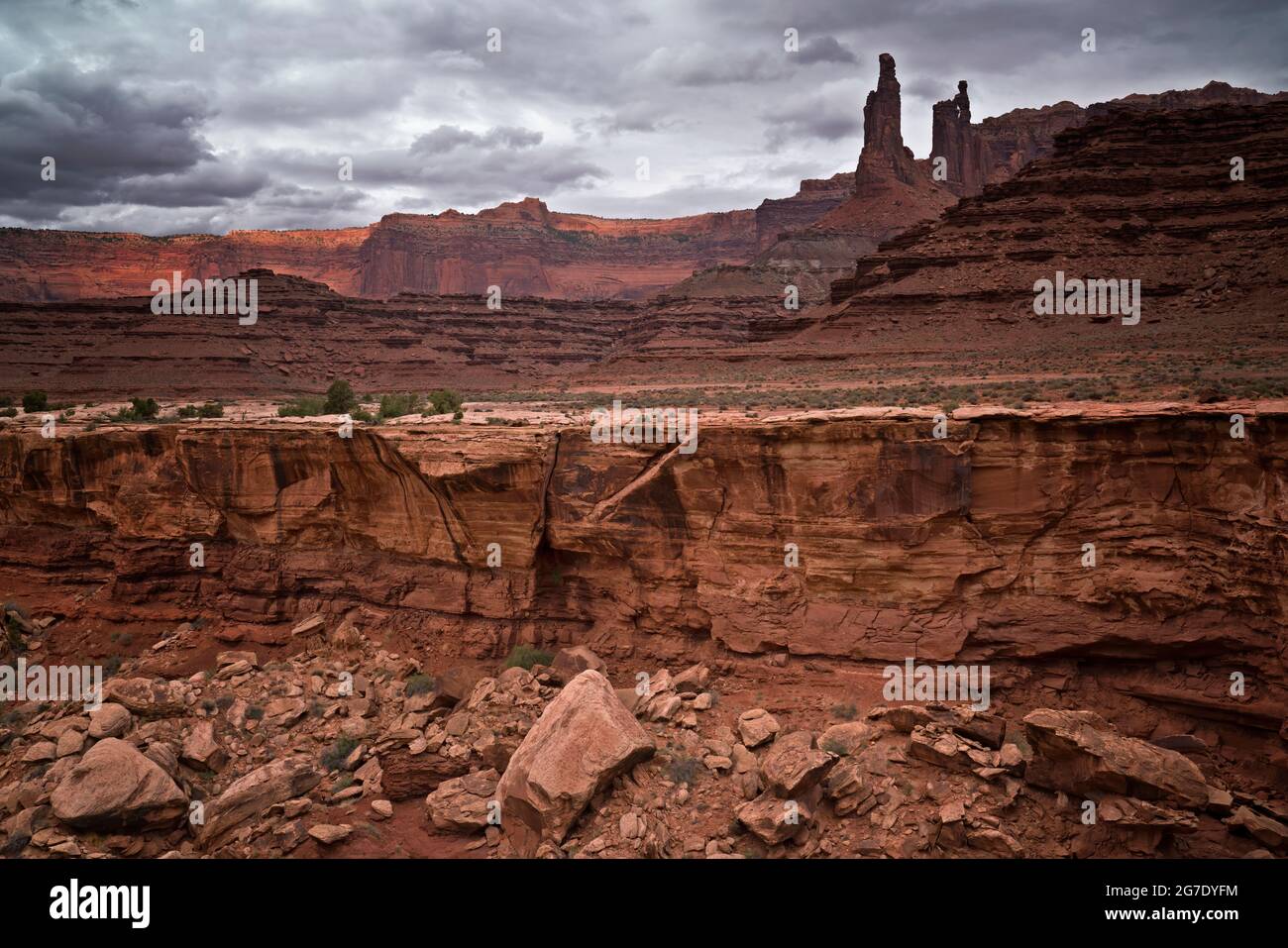 Early morning sunbreaks and thunderstorms form over Monster Tower and Washer Woman Arch on the remote White Rim Road in Utah’s Canyonlands National Pa Stock Photo