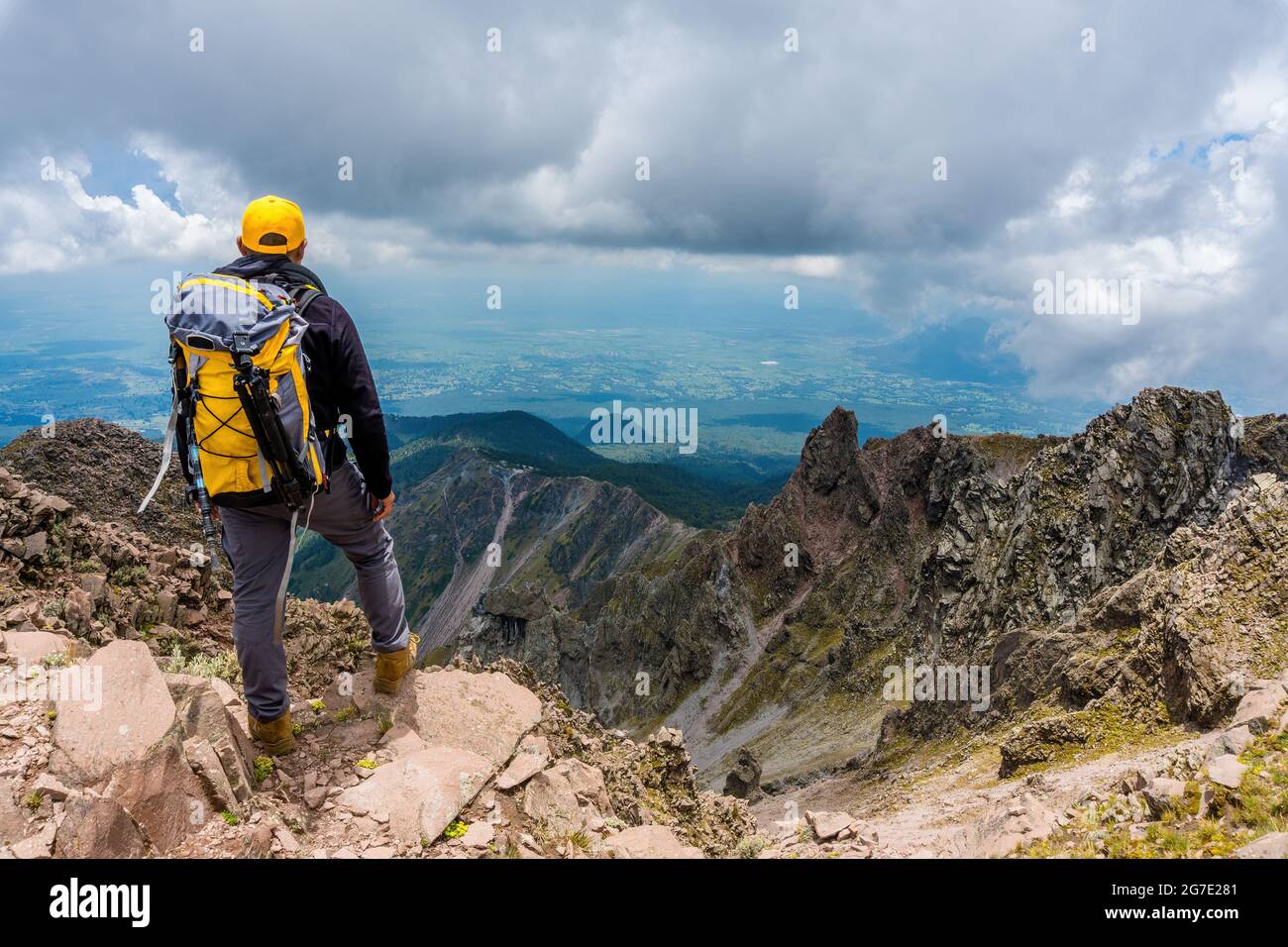 Hiker with a backpack standing on the top of the mountain Stock Photo ...