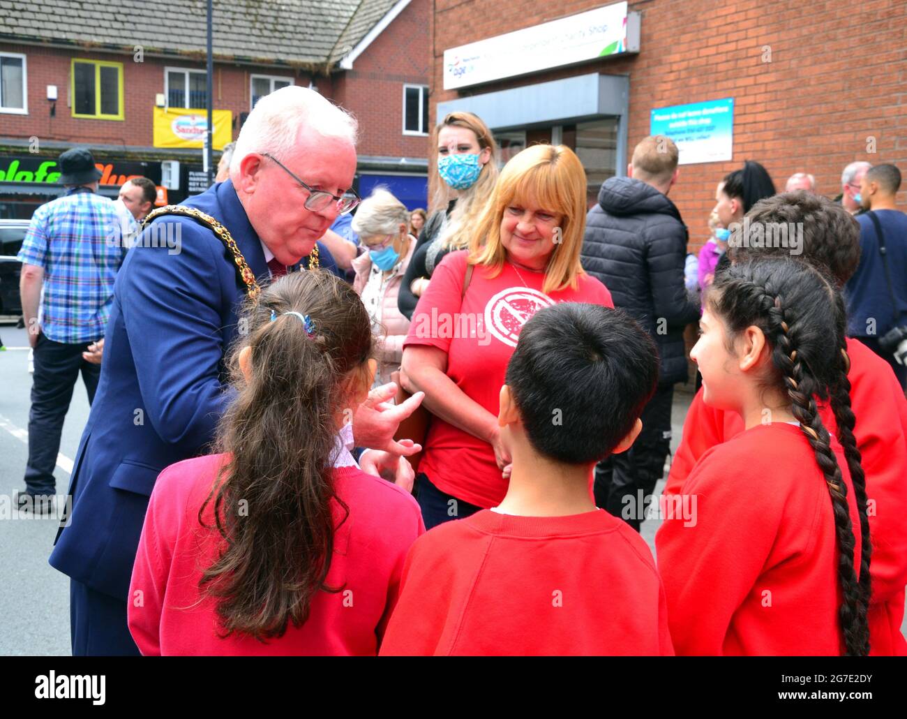 The Lord Mayor of the City of Manchester, Councillor Tommy Judge, talks to children beside the giant Marcus Rashford mural in Withington, Manchester, England, United Kingdom, that was vandalised  with abusive graffiti after England's Euro2020 football loss  on July 11th, 2021. The mural was created by French-born street artist Akse P19 on the wall of the Coffee House Cafe on Copson Street. Marcus Rashford is a Manchester United football player. Akse fully repaired the damaged mural by 13th July, 2021. Picture date: July 13th, 2021. Stock Photo