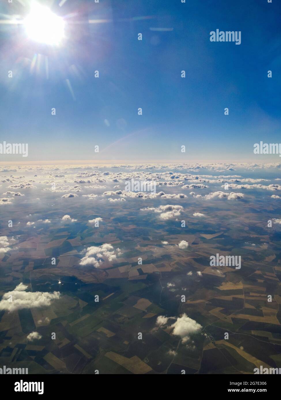 Aerial shot of the farms and fields captured from above the clouds ...