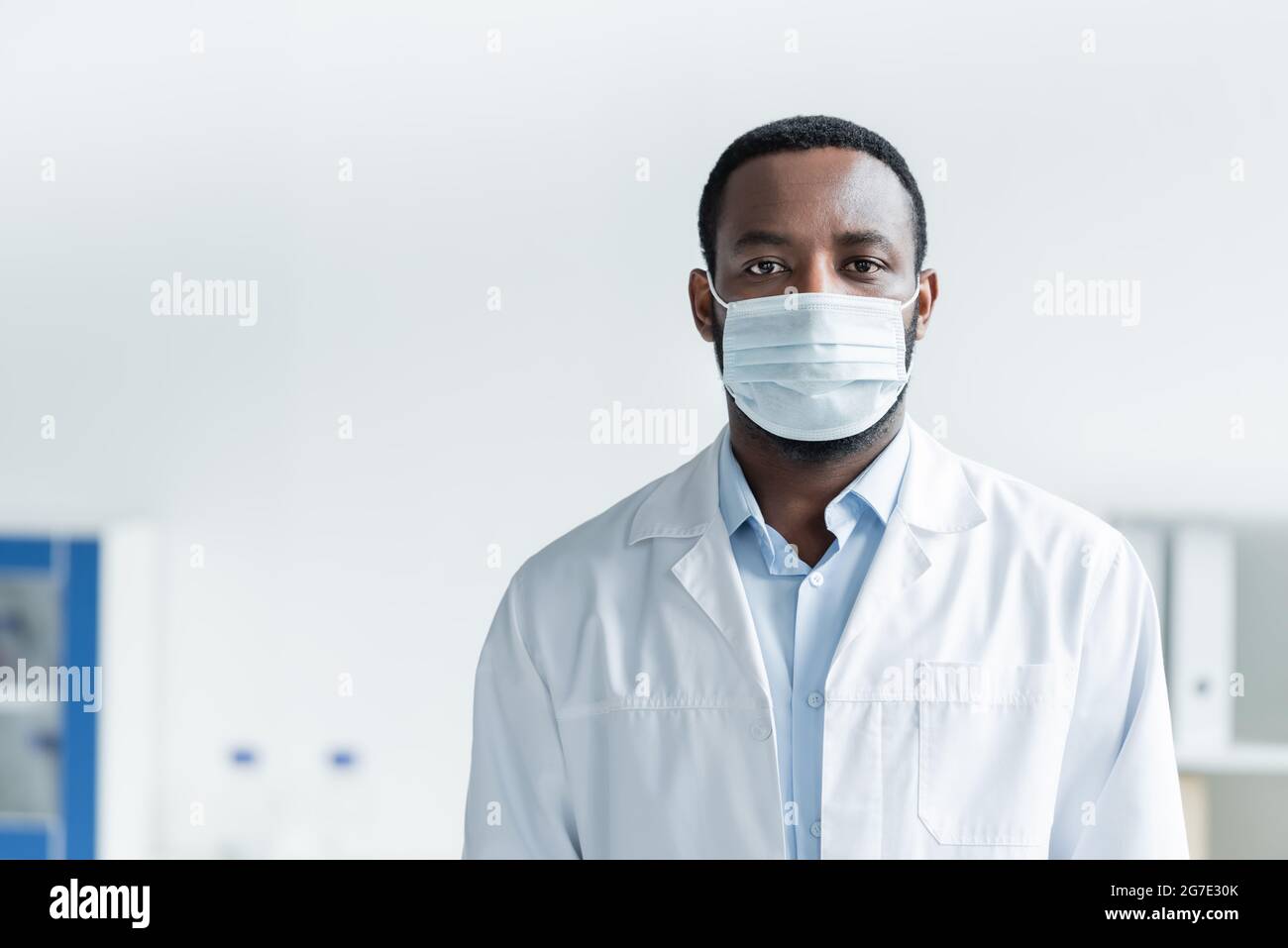 African american doctor in protective mask standing in hospital Stock ...