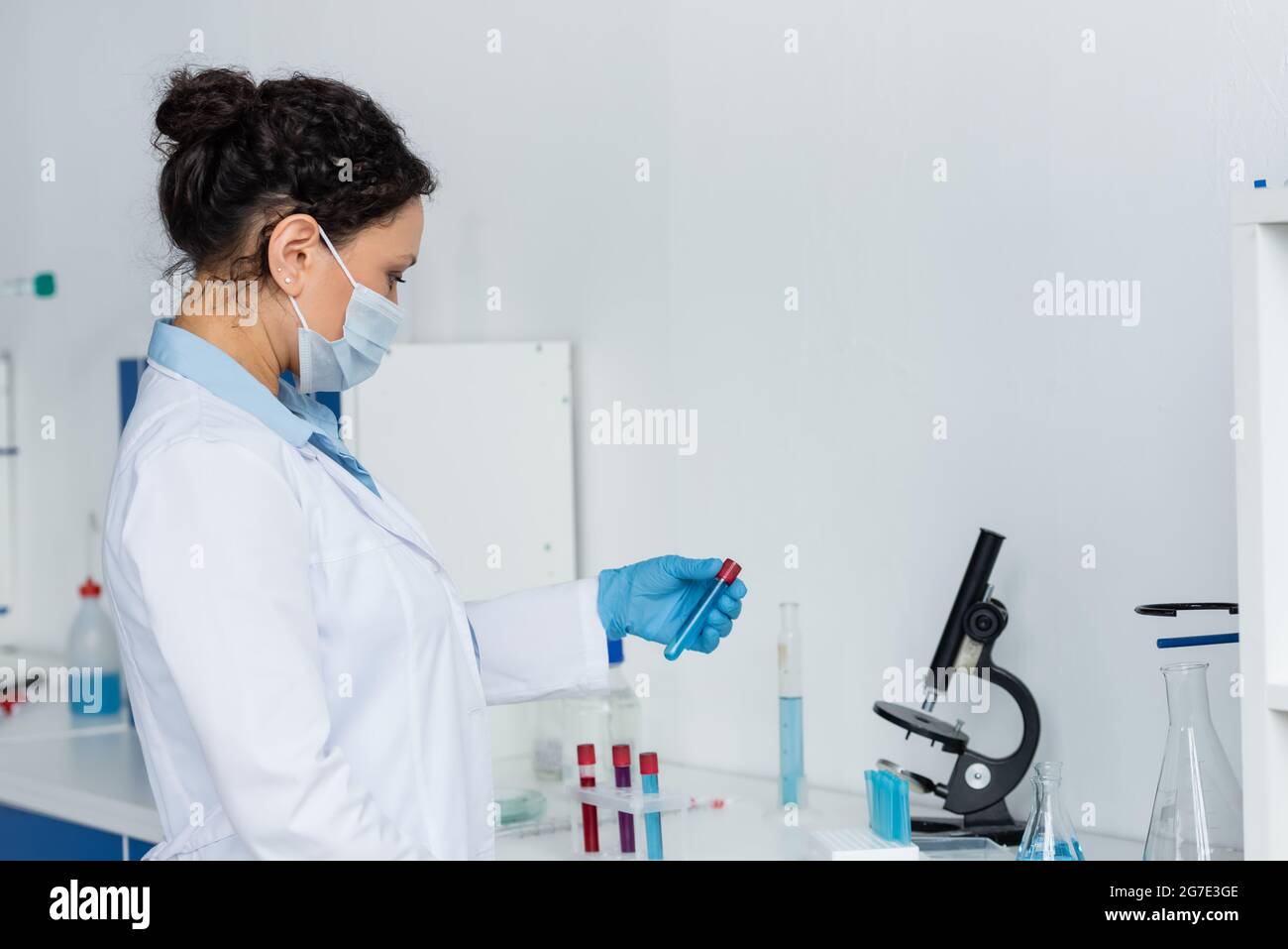 Side view of african american scientist in medical mask and white coat ...