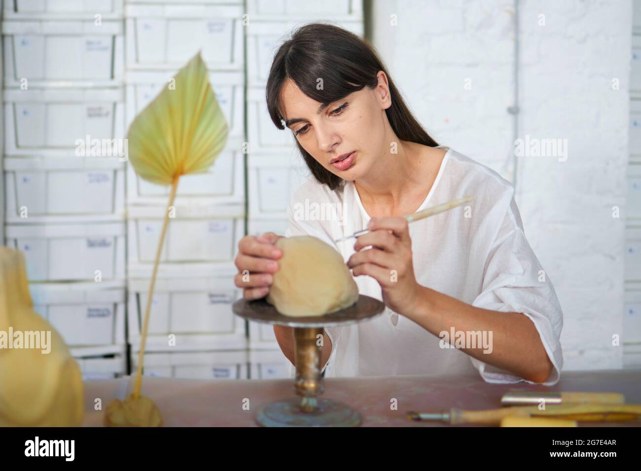 An artist working with pottery during her pottery class Stock Photo