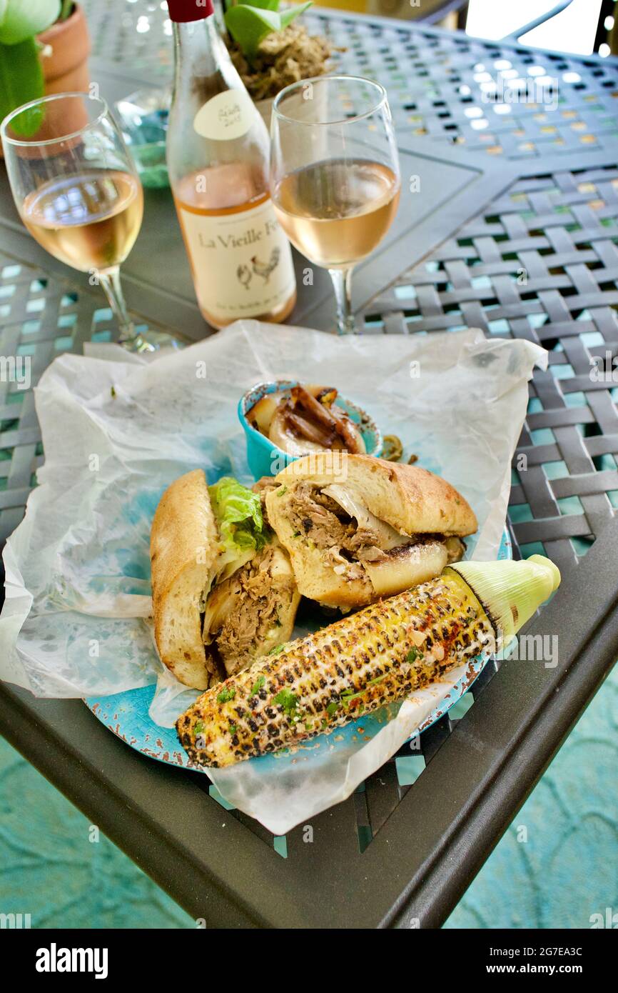 Caribbean Roast Pork sandwich with grilled corn and rose wine pool side in Key West, Florida, FL Stock Photo
