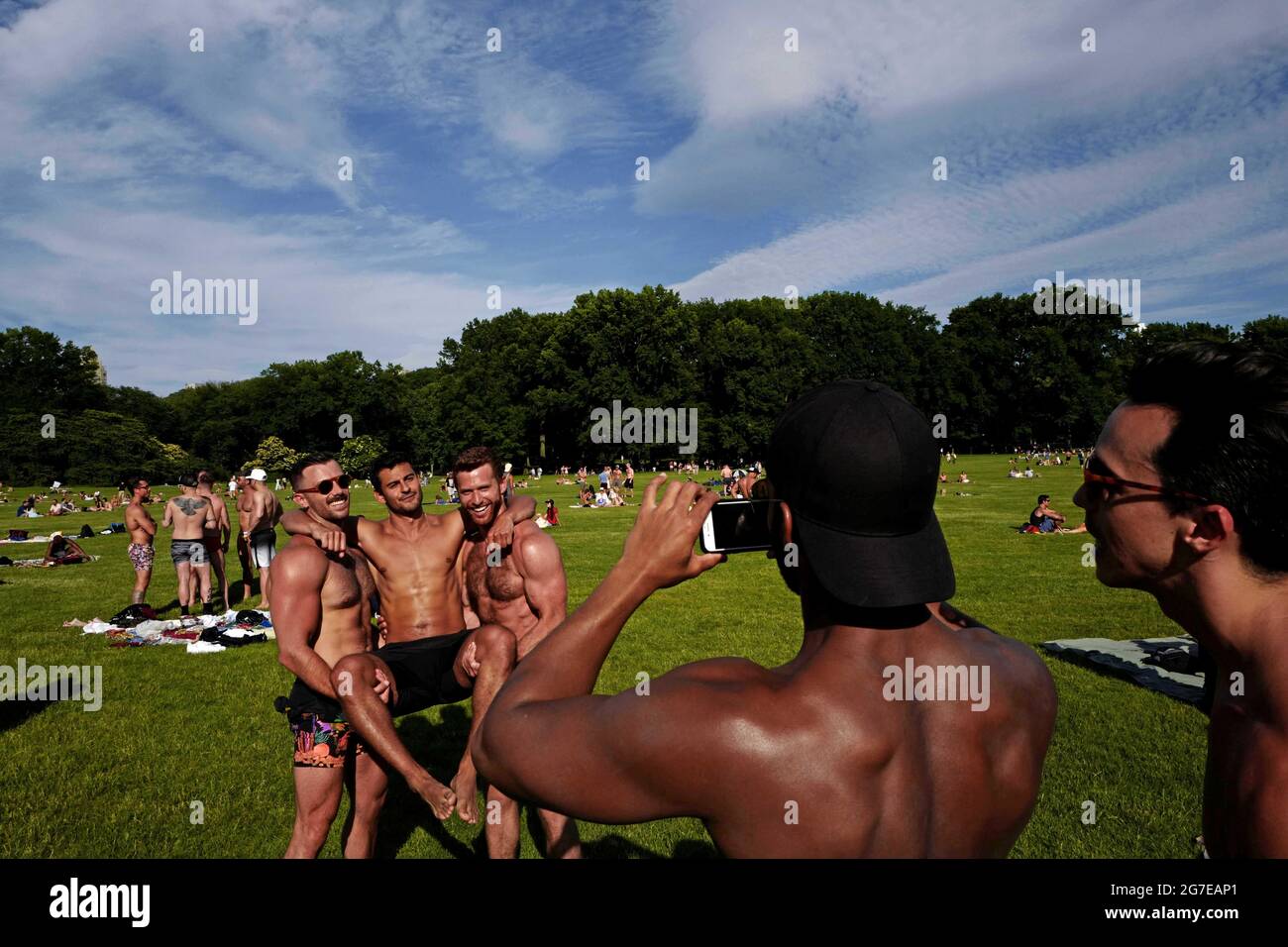 Swimsuit guys gathering at Central Park on an hot summer saturday afternoon, in New York City. Stock Photo
