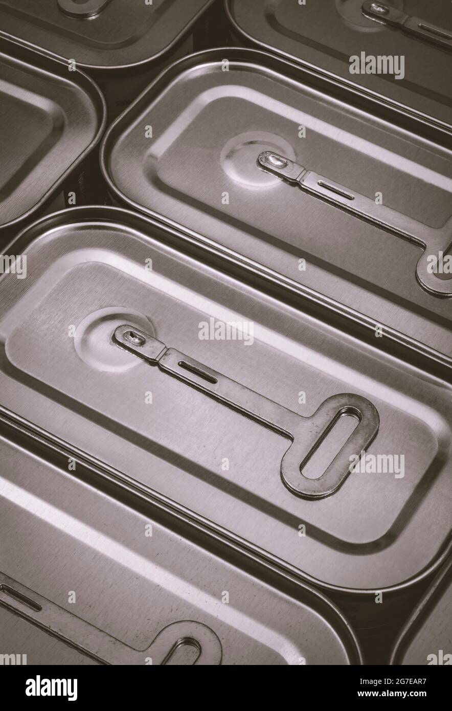 Monochrome twist-key tin opener / can-opener on an ASDA luncheon meat tinned product. Concept for food preservation, opening a can of worms. Stock Photo
