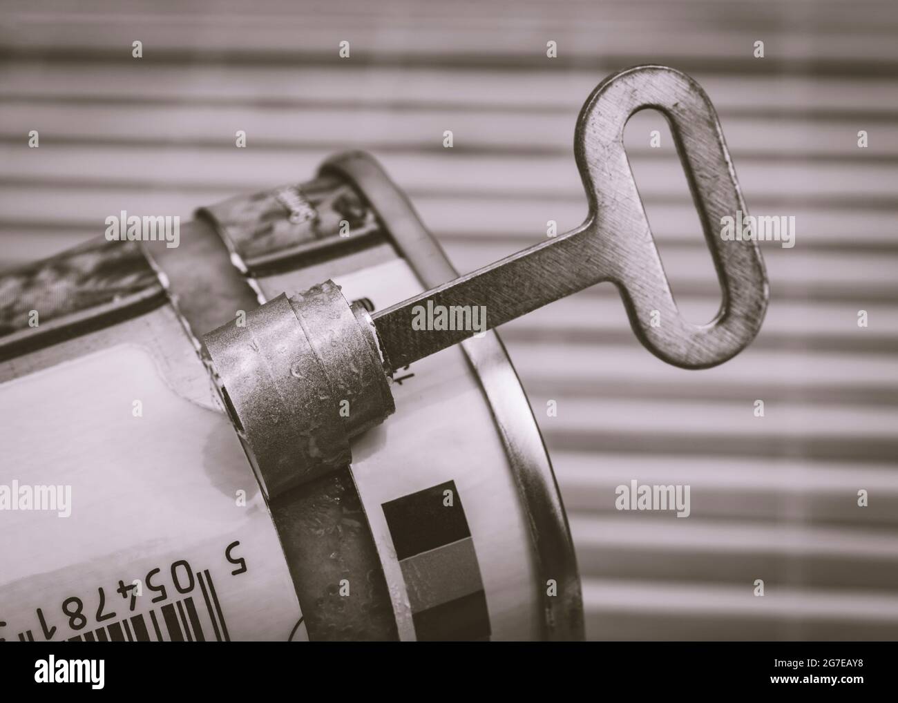 Monochrome twist-key tin opener / can-opener on an ASDA luncheon meat tinned product. Concept for food preservation, opening a can of worms. Stock Photo