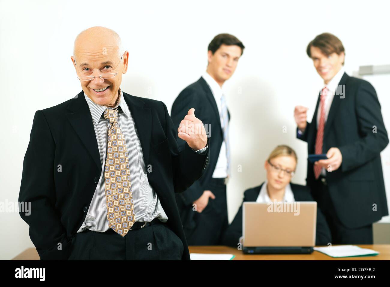 business team with a portrait of the very confident team leader in foreground (selective focus on the team leader!) Stock Photo